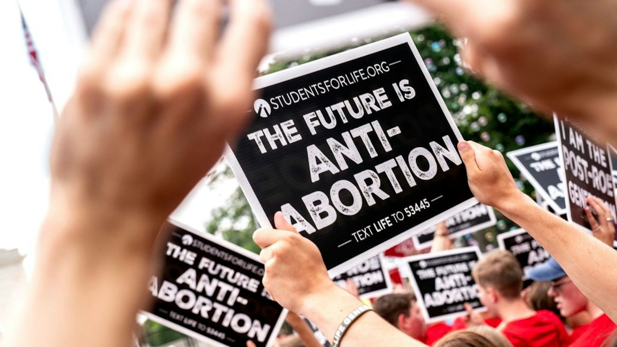 Anit-abortion activists hold signs outside the US Supreme Court in Washington, DC, on June 24, 2022. - The US Supreme Court on Friday ended the right to abortion in a seismic ruling that shreds half a century of constitutional protections on one of the most divisive and bitterly fought issues in American political life. The conservative-dominated court overturned the landmark 1973 "Roe v Wade" decision that enshrined a woman's right to an abortion and said individual states can permit or restrict the procedure themselves. (Photo by Stefani Reynolds / AFP) (Photo by STEFANI REYNOLDS/AFP via Getty Images)
