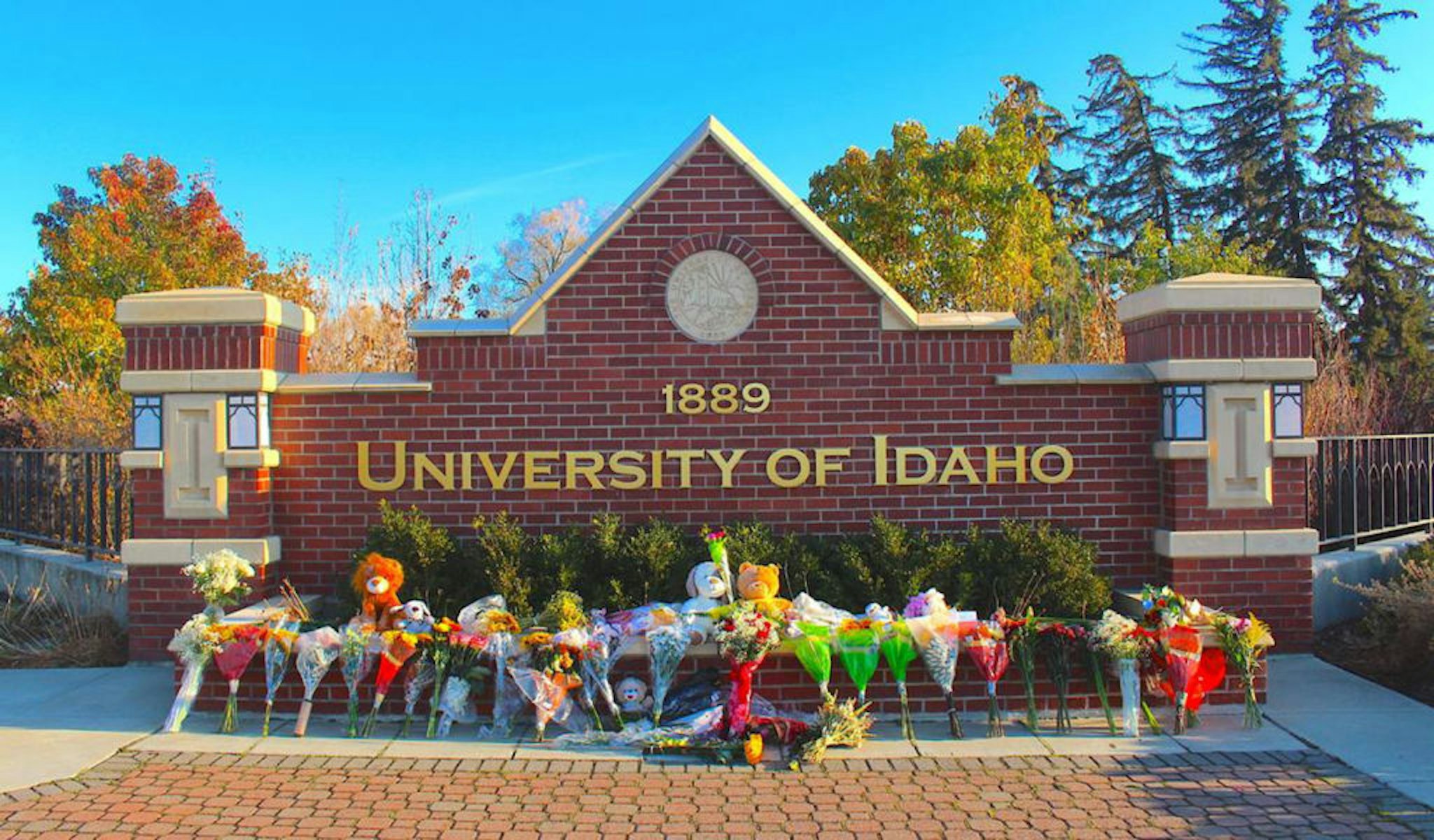 Flowers, notes and stuffed animals sit along the University of Idaho's entrance sign on Pullman Road in Moscow to honor the four students stabbed to death in an off-campus home on Nov. 13