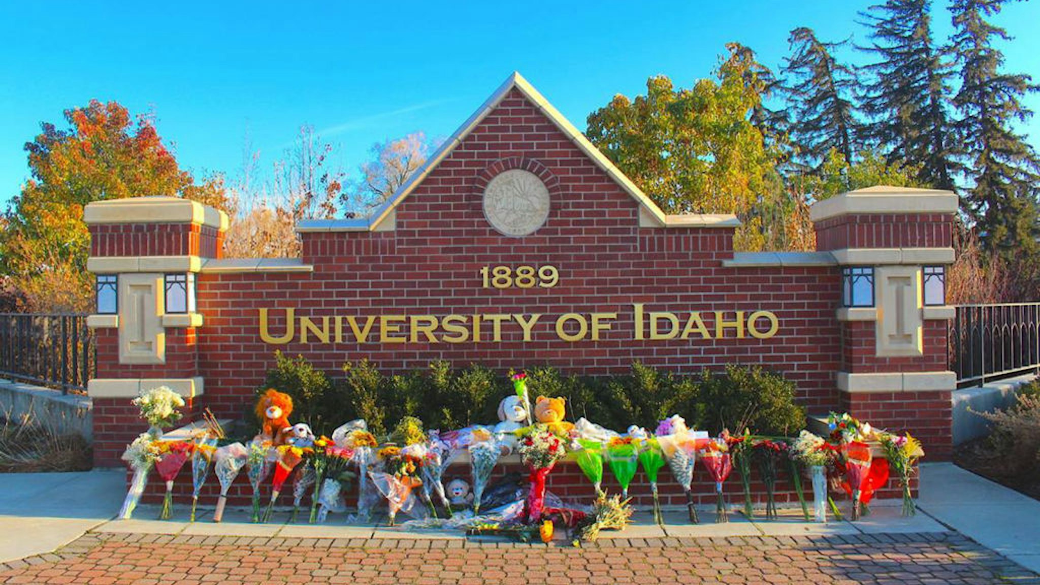 Flowers, notes and stuffed animals sit along the University of Idaho's entrance sign on Pullman Road in Moscow to honor the four students stabbed to death in an off-campus home on Nov. 13