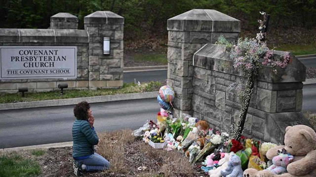 Robin Wolfenden prays at a makeshift memorial for victims outside the Covenant School building at the Covenant