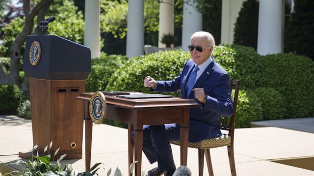 U.S. President Joe Biden remarks that the desk is hot from the sun before signing an executive order that would create the White House Office of Environmental Justice, in the Rose Garden of the White House April 21, 2023 in Washington, DC.