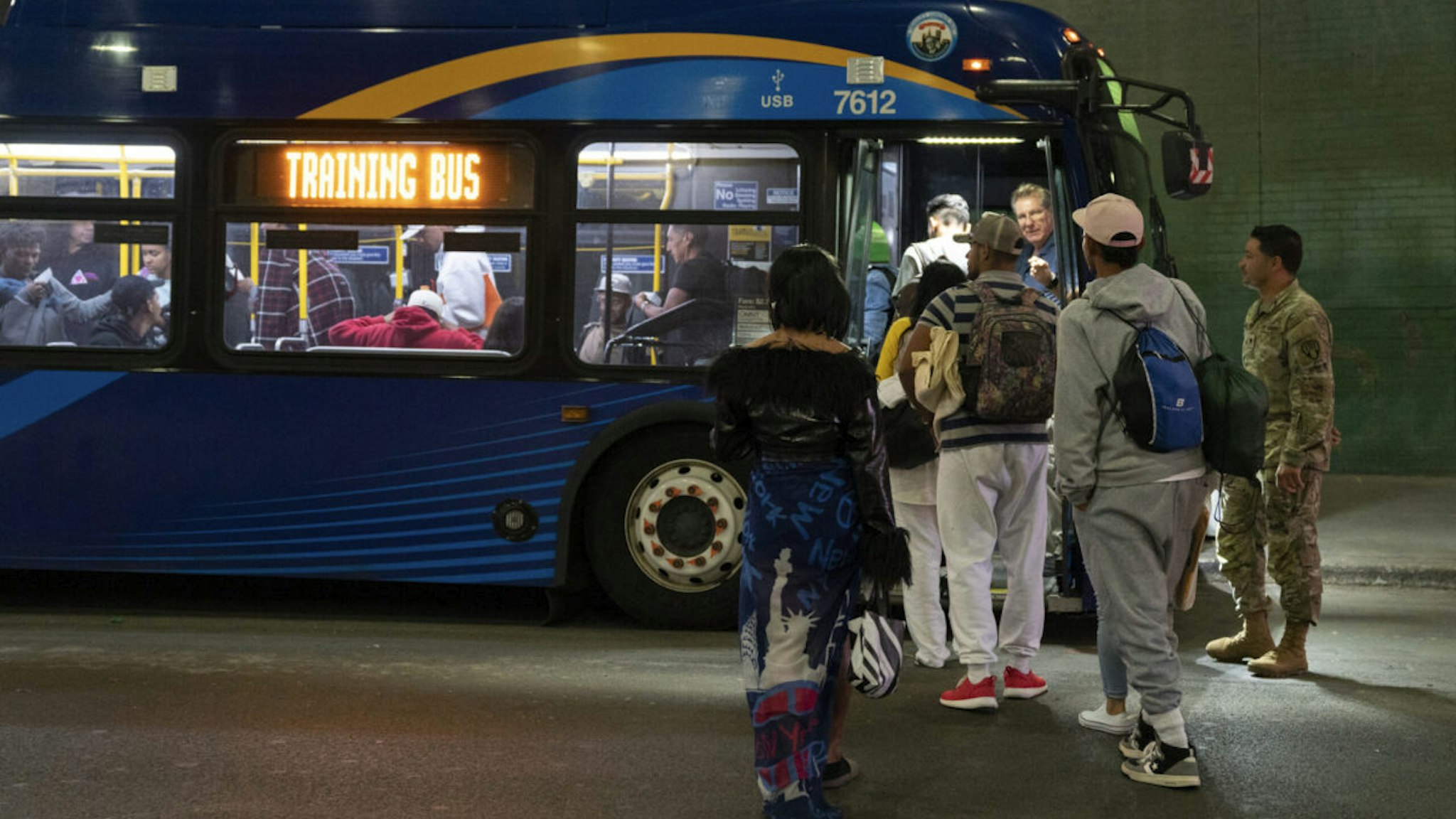 Immigrants leave the Port Authority Bus Terminal on 8th Ave. for a city run processing center on a MTA bus Saturday, May, 13, 2023 in Manhattan, New York.