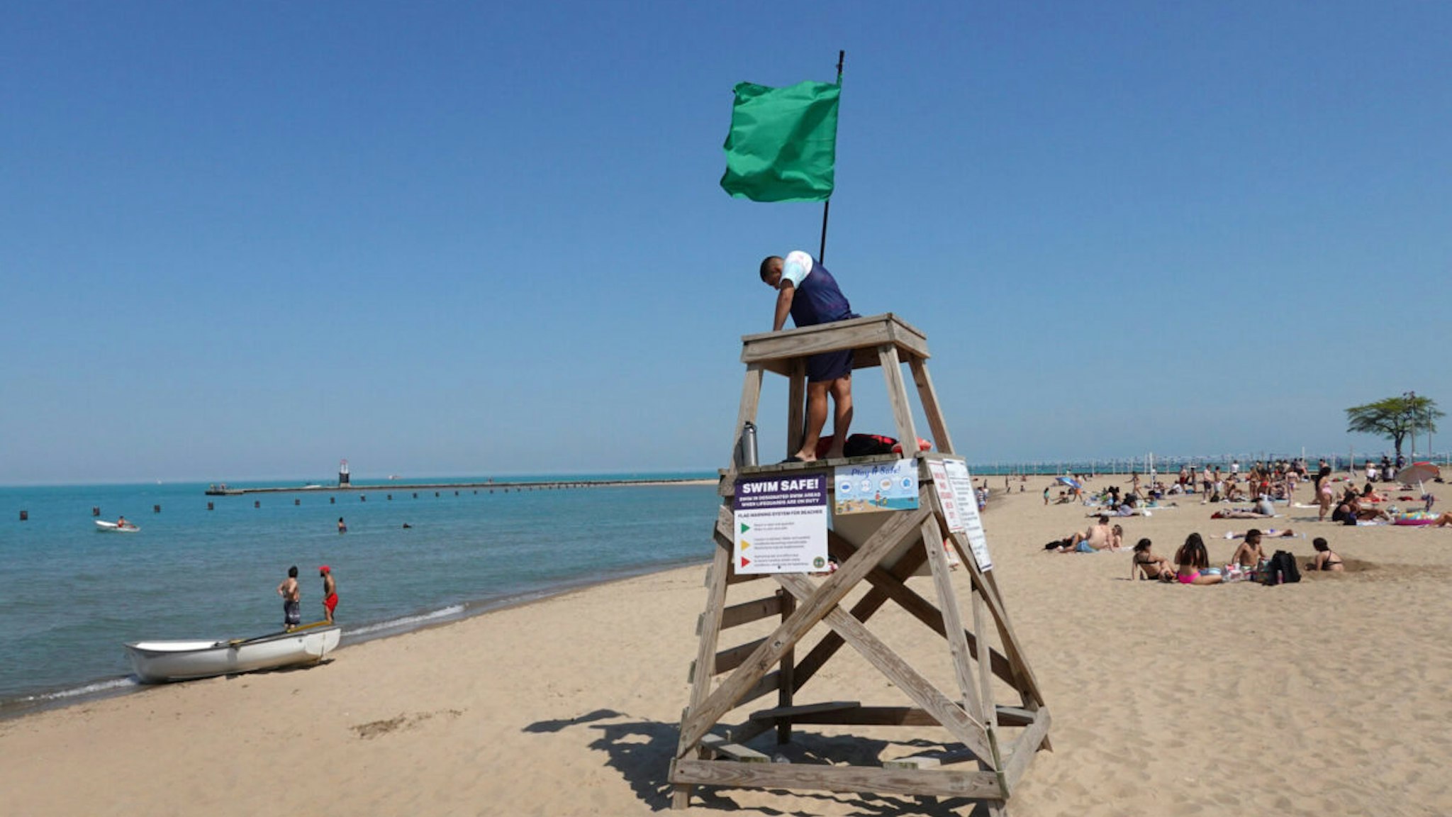 CHICAGO, ILLINOIS - JUNE 03: A lifeguard keeps watch over beachgoers at North Avenue Beach on June 03, 2021 in Chicago, Illinois. Nationwide, municipalities have had difficulty filling lifeguard jobs. Part of the problem has been attributed to the cancelation of lifeguard training programs in 2020 due to the COVID-19 pandemic.