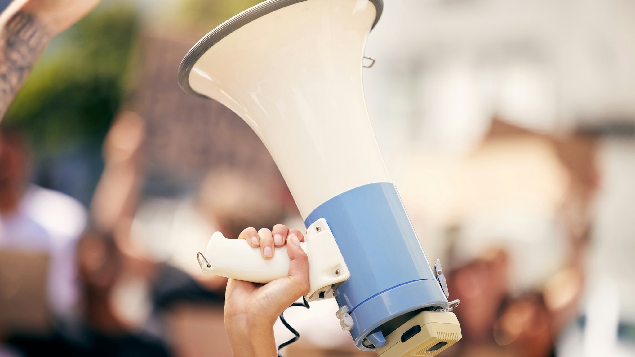 Shot of a protester holding a megaphone during a rally - stock photo