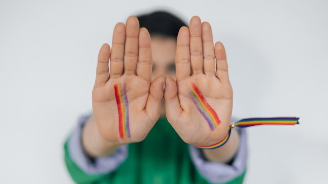Child hands painted as rainbow flag LGBTQ+