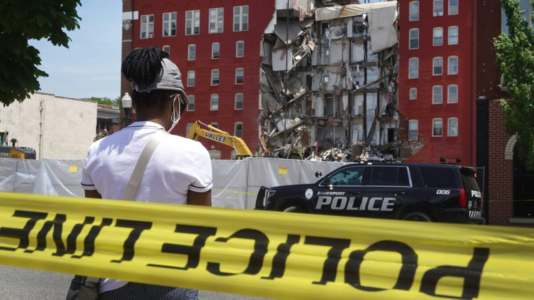 DAVENPORT, IOWA - MAY 29: People view a six-story apartment building after it collapsed yesterday on May 29, 2023 in Davenport, Iowa. Eight people were rescued from the debris following the collapse yesterday afternoon.