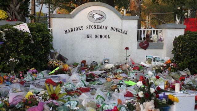 Flowers, candles and mementos sit outside one of the makeshift memorials at Marjory Stoneman Douglas High School in Parkland, Florida on February 27, 2018. Florida's Marjory Stoneman Douglas high school will reopen on February 28, 2018 two weeks after 17 people were killed in a shooting by former student, Nikolas Cruz, leaving 17 people dead and 15 injured on February 14, 2018. / AFP PHOTO / RHONA WISE