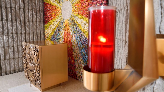 Red Sanctuary Lamp or Eternal Flame at the Tabernacle with bronze Lamb of God bas relief at side altar with sunburst mosaic in Catholic church. (Photo by: Education Images/Universal Images Group via Getty Images)