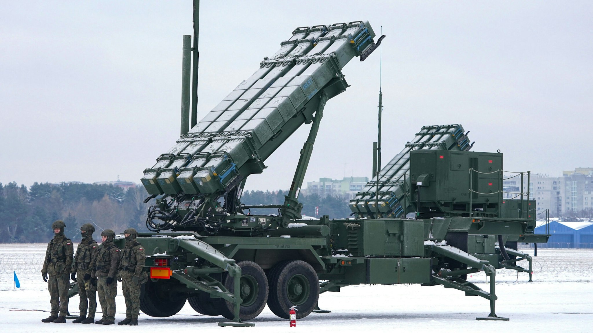 Soldiers stand in front of a PATRIOT (Phased Array Tracking Radar to Intercept on Target) surface-to-air missile system during a military exercise at Warsaw Babice Airport, Poland on February 7, 2023. - Patriot missile systems purchased by Poland last year have been redeployed to the Polish captital for military exercises.