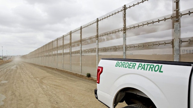 A U.S. Border Patrol vehicle sits parked next to a secondary fence along the U.S.-Mexico border in San Diego, California. Photographer: Daniel Acker/Bloomberg