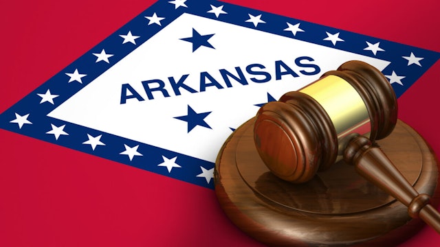 Arkansas US state law, code, legal system and justice concept with a 3d render of a gavel on the Arkansan flag on background.