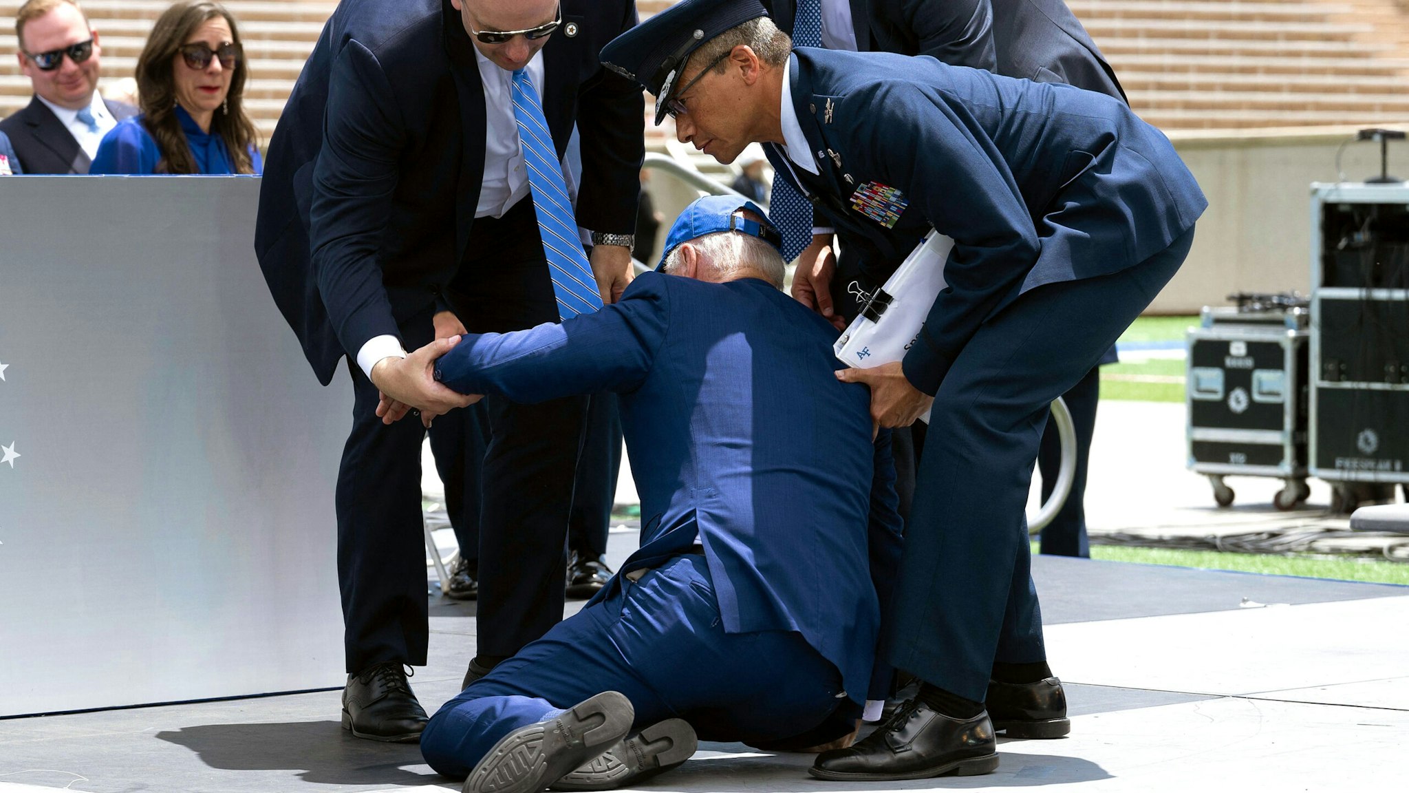 US President Joe Biden is helped up after falling during the graduation ceremony at the United States Air Force Academy, just north of Colorado Springs in El Paso County, Colorado, on June 1, 2023.