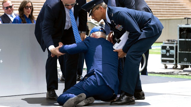 US President Joe Biden is helped up after falling during the graduation ceremony at the United States Air Force Academy, just north of Colorado Springs in El Paso County, Colorado, on June 1, 2023.