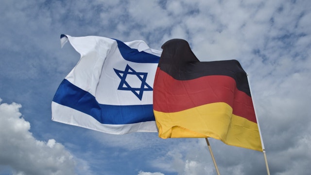 Flag of Israel an Germany are joining in the cloudy sky
