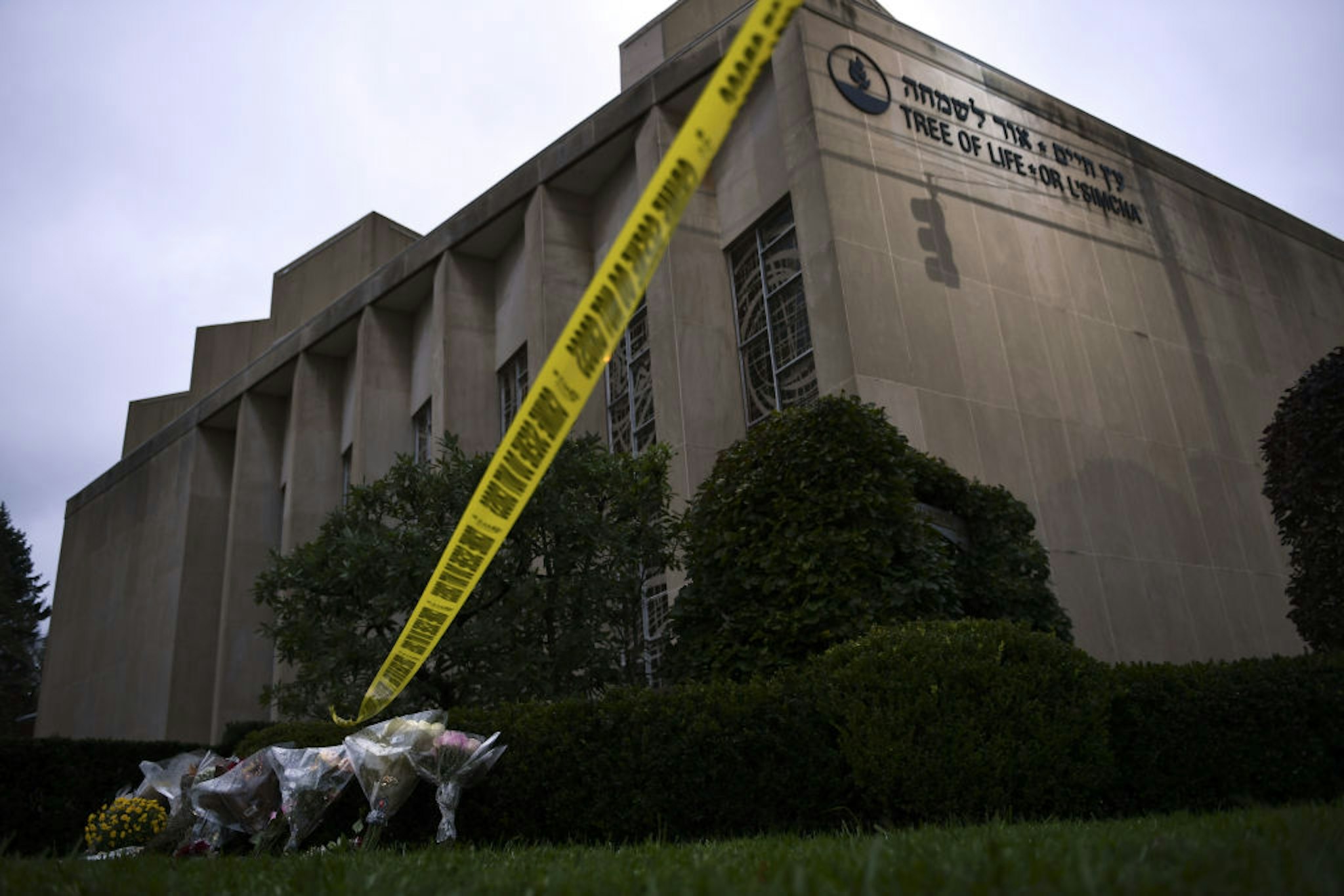 Police tape and memorial flowers are seen on October 28, 2018 outside the Tree of Life Synagogue after a shooting there left 11 people dead in the Squirrel Hill neighborhood of Pittsburgh on October 27, 2018. - A man suspected of bursting into a Pittsburgh synagogue during a baby-naming ceremony and gunning down 11 people has been charged with murder, in the deadliest anti-Semitic attack in recent US history. The suspect -- identified as a 46-year-old Robert Bowers -- reportedly yelled "All Jews must die" as he sprayed bullets into the Tree of Life synagogue during Sabbath services on Saturday before exchanging fire with police, in an attack that also wounded six people. (Photo by Brendan Smialowski / AFP)