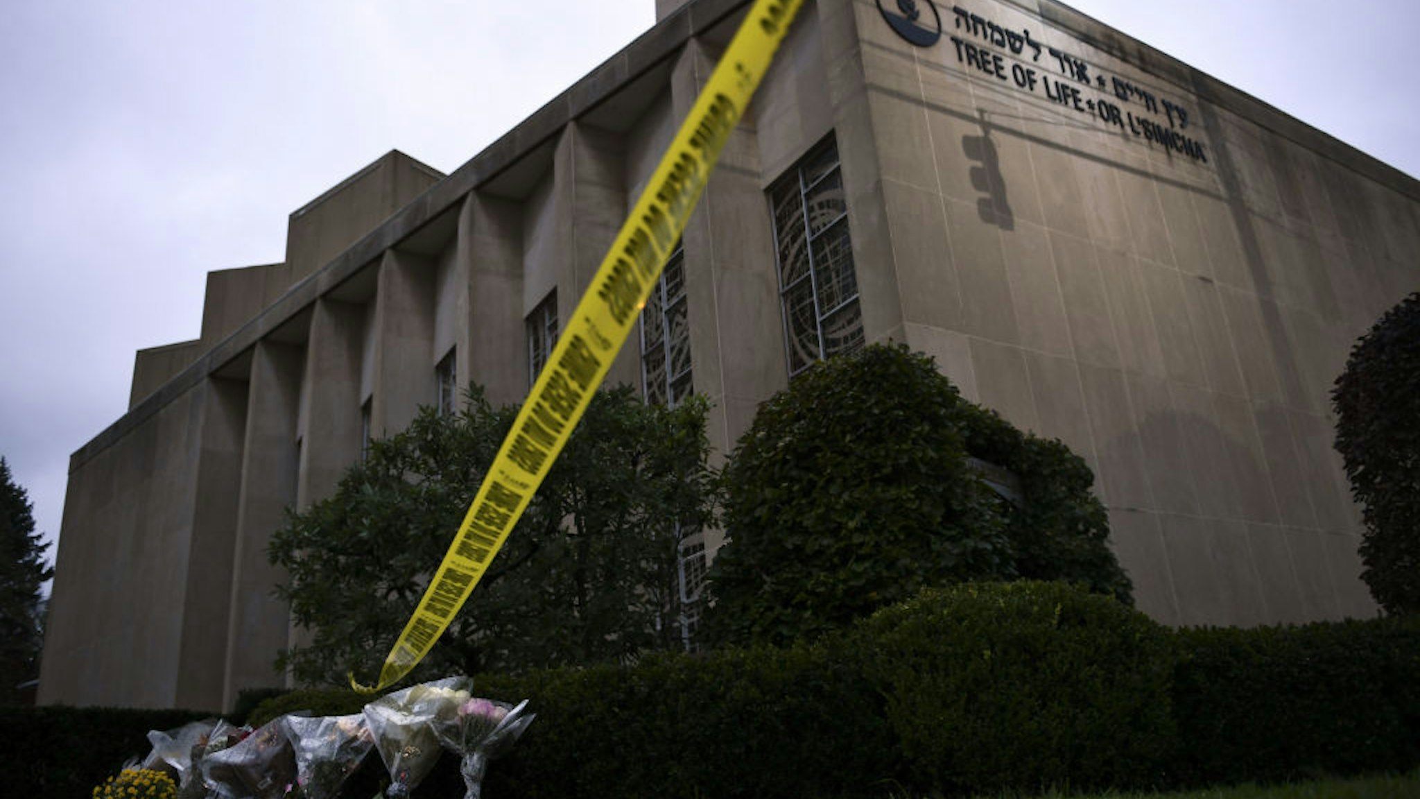 Police tape and memorial flowers are seen on October 28, 2018 outside the Tree of Life Synagogue after a shooting there left 11 people dead in the Squirrel Hill neighborhood of Pittsburgh on October 27, 2018. - A man suspected of bursting into a Pittsburgh synagogue during a baby-naming ceremony and gunning down 11 people has been charged with murder, in the deadliest anti-Semitic attack in recent US history. The suspect -- identified as a 46-year-old Robert Bowers -- reportedly yelled "All Jews must die" as he sprayed bullets into the Tree of Life synagogue during Sabbath services on Saturday before exchanging fire with police, in an attack that also wounded six people. (Photo by Brendan Smialowski / AFP)