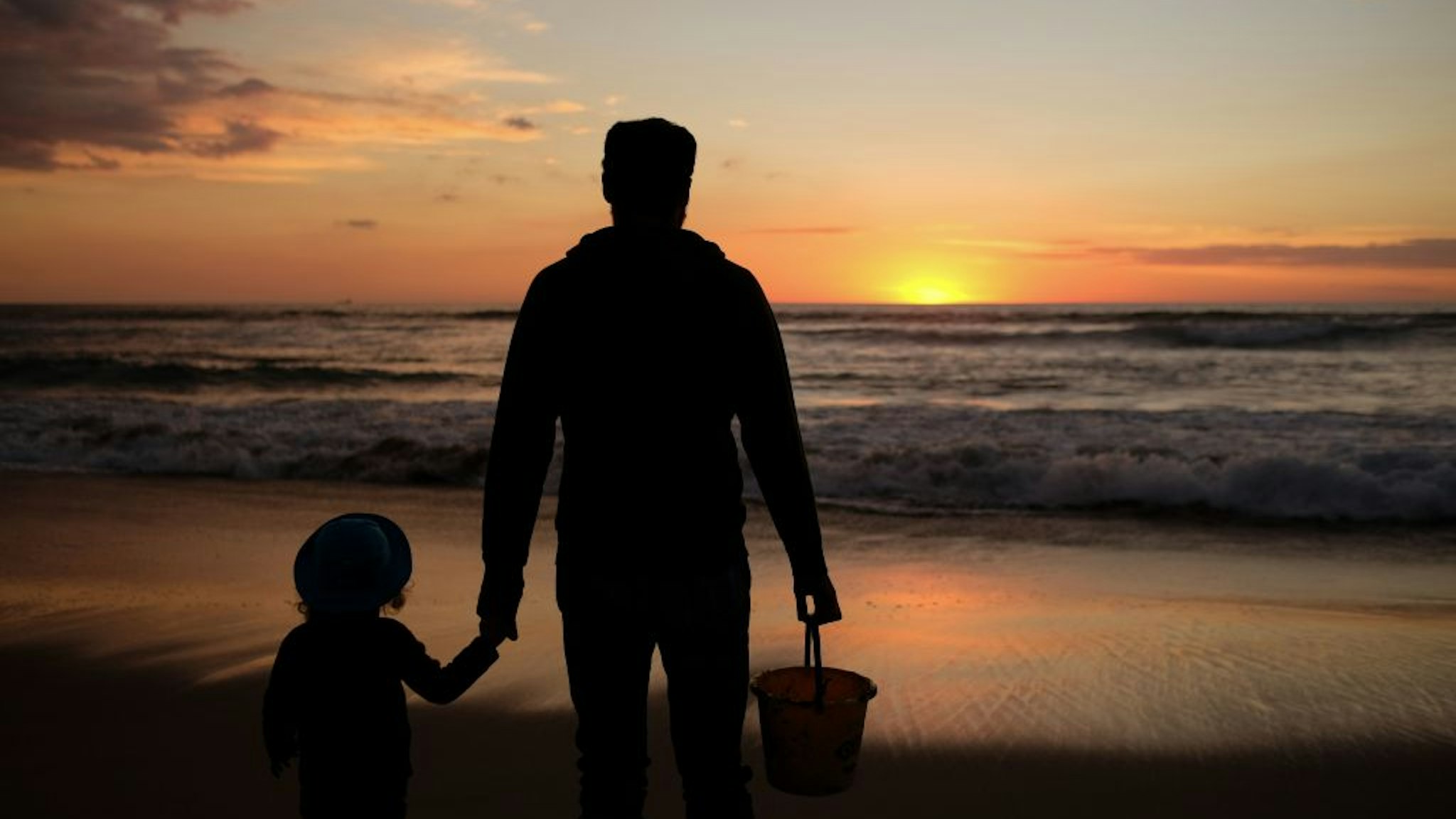 A dad and his daughter enjoy the last sunset of the year in Manhattan Beach, California, on December 31, 2018. (Photo by Chris Delmas / AFP) (Photo credit should read CHRIS DELMAS/AFP via Getty Images)