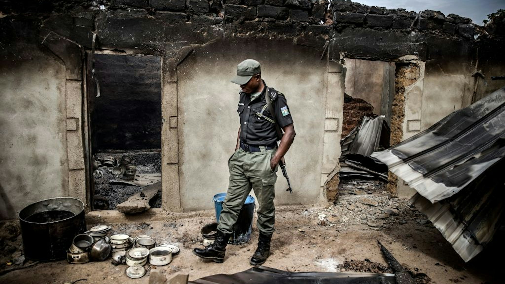 A Nigerian Police Officer patrols an area of destroyed and burned houses after a recent Fulani attack in the Adara farmers' village of Angwan Aku, Kaduna State, Nigeria on April 14, 2019. - The ongoing strife between Muslim herders and Christian farmers, which claimed nearly 2,000 lives in 2018 and displaced hundreds of thousands of others, is a divisive issue for Nigeria and some other countries in West Africa. (Photo by Luis TATO / AFP)
