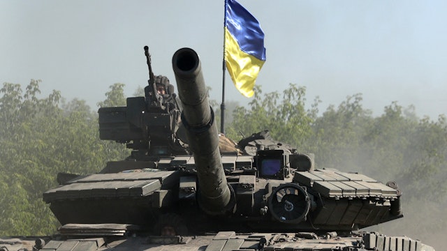 TOPSHOT - Ukrainian troop ride a tank on a road of the eastern Ukrainian region of Donbas on June 21, 2022, as Ukraine says Russian shelling has caused "catastrophic destruction" in the eastern industrial city of Lysychansk, which lies just across a river from Severodonetsk where Russian and Ukrainian troops have been locked in battle for weeks. - Regional governor Sergiy Gaiday says that non-stop shelling of Lysychansk on June 20 destroyed 10 residential blocks and a police station, killing at least one person. (Photo by Anatolii Stepanov / AFP) (Photo by ANATOLII STEPANOV/AFP via Getty Images)