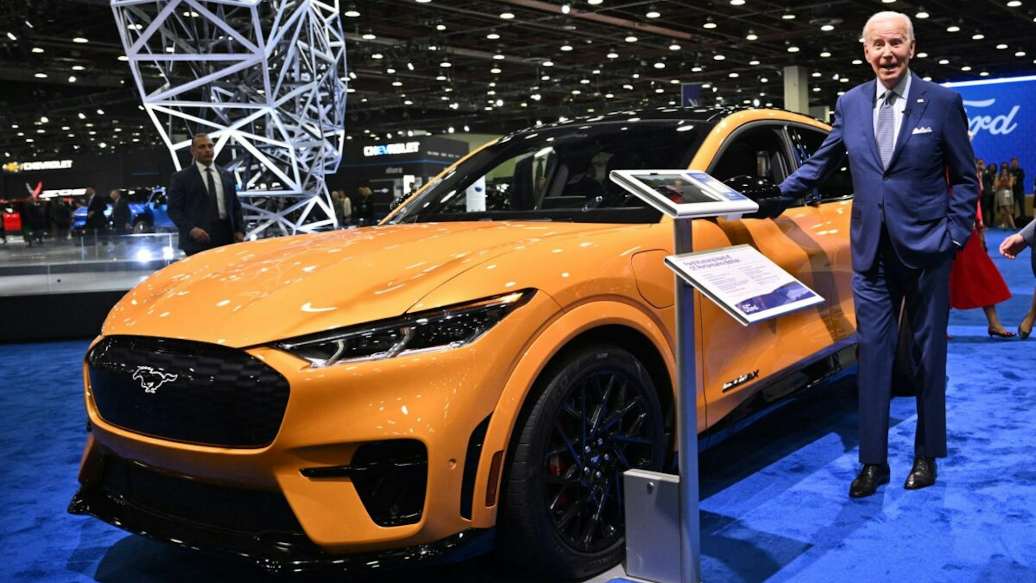 US President Joe Biden looks at an electric Ford Mustang as he tours the 2022 North American International Auto Show at Huntington Place Convention Center in Detroit, Michigan on September 14, 2022. - Biden is visiting the auto show to highlight electric vehicle manufacturing.
