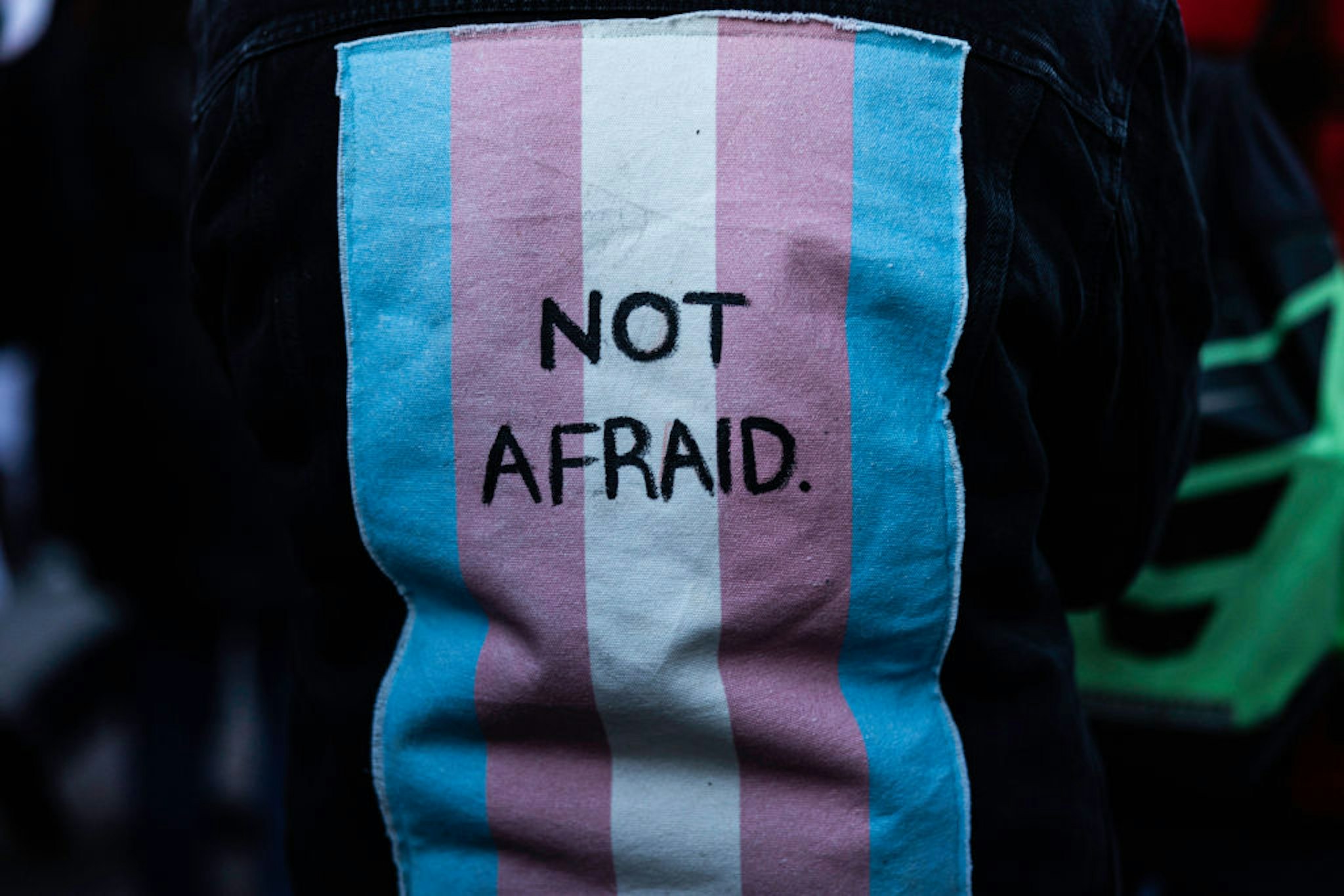 NEW YORK, NY - NOVEMBER 20: A person wears a vest with a trans flag on the back with the words Not afraid during a memorial honoring trans individuals killed by gun violence held by Gays Against Guns on November 20, 2022 in New York City. Although planned in advance, this event coincides with a mass shooting in Colorado at a bar designated as a safe place for the LGBTQIA+ community. (Photo by Alex Kent/Getty Images)