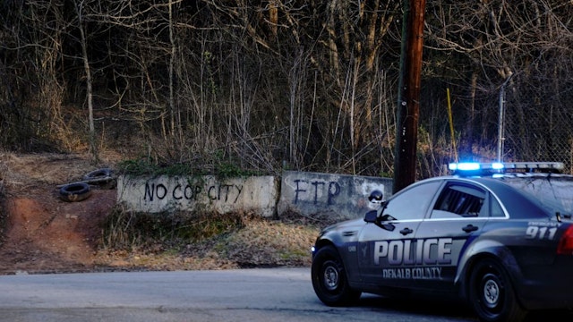 Law enforcement drive past the planned site of a police training facility that activists have nicknamed "Cop City", following the first raid since the death of environmental activist Manuel Teran near Atlanta, Georgia, on February 6, 2023. - Teran was allegedly shot by police on January 18, 2023, during a confrontation as officers cleared activists from a forest, the planned site of a police-training facility. (Photo by CHENEY ORR / AFP