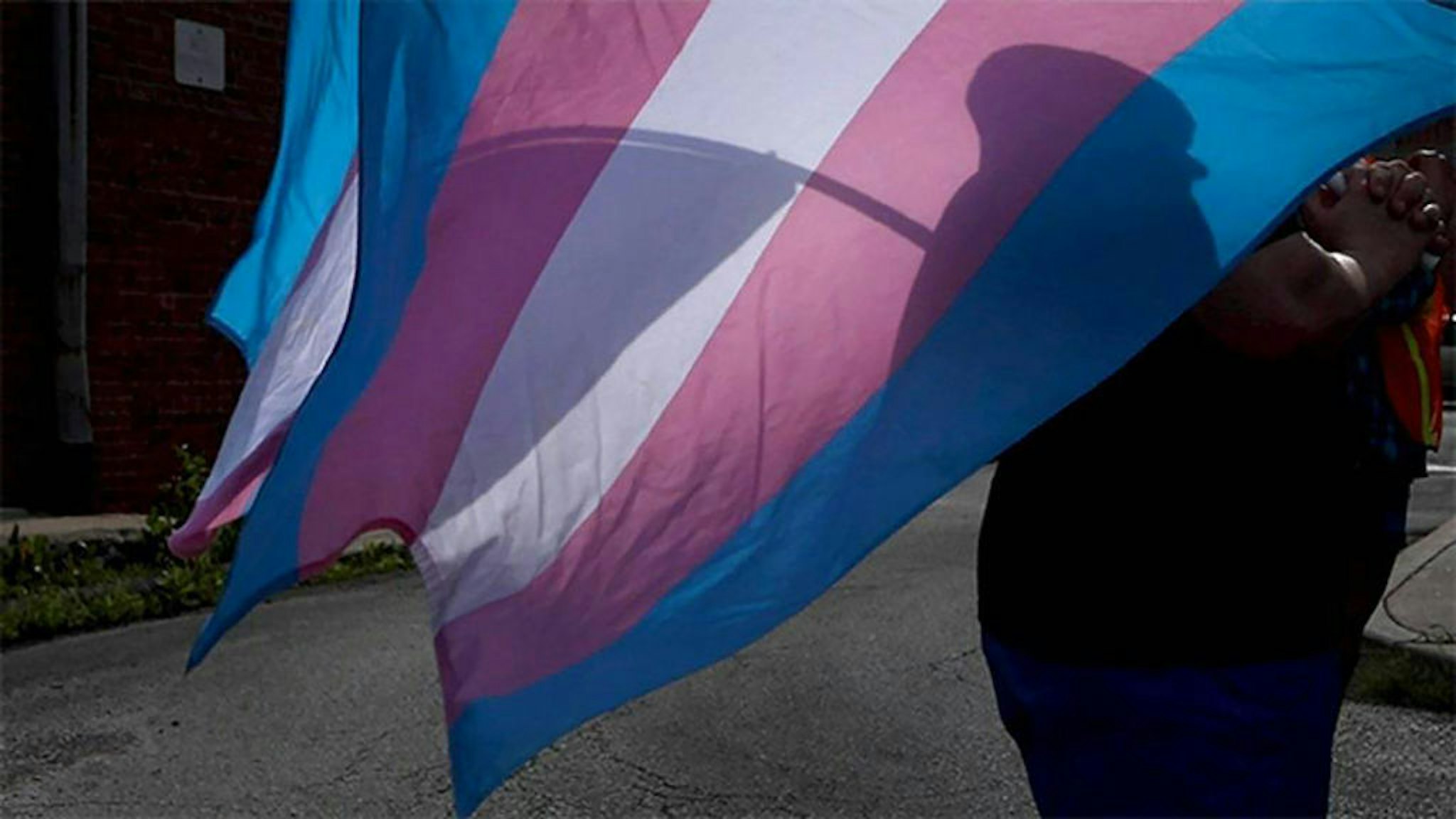 A marcher carries a Transgender Pride flag during a march in Kansas City. Lawmakers in Kansas and Missouri weighing bills that target the LGBTQ community. (The Kansas City Star/Tribune News Service via Getty Images)