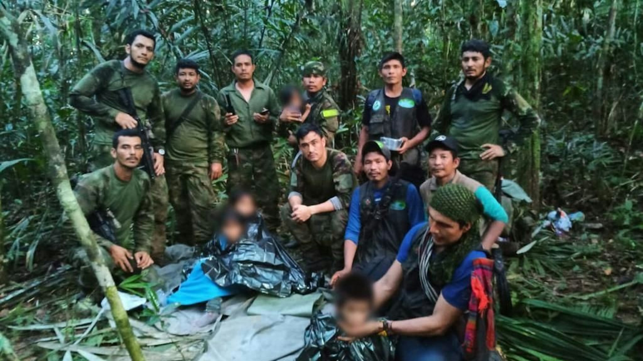 JUNGLE, COLOMBIA - JUNE 9: (EDITOR'S NOTE: This image has been altered â" child's face has been blurred) (----EDITORIAL USE ONLY - MANDATORY CREDIT - 'COLOMBIAN MILITARY FORCES / HANDOUT' - NO MARKETING NO ADVERTISING CAMPAIGNS - DISTRIBUTED AS A SERVICE TO CLIENTS----) Colombian Military Forces pose for a photo as they found four children who survived 40 days in the Amazon jungle after their plane crashed, in the department of Caqueta on June 9, 2023. A miracle in the jungle is how Colombians are describing the discovery Friday of four indigenous children who survived 40 days in the Amazon jungle after their plane crashed. The children were flying May 1 from Araracuara, in Amazonas province, to San Jose del Guaviare, in southeastern Colombia when the plane malfunctioned and crashed. Three adults, including the children's mother, died.
