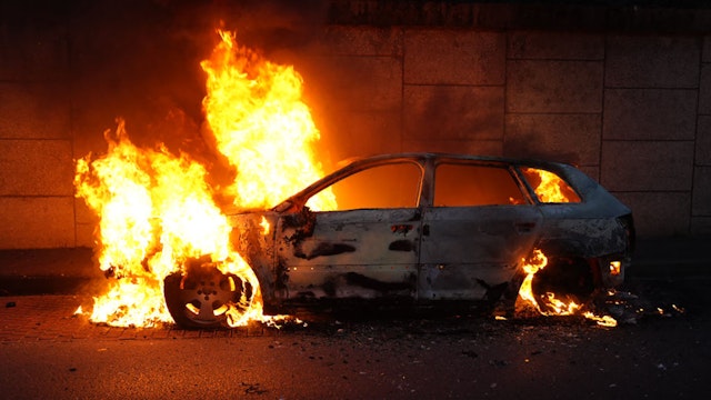 A photo shows a burning car on the sidelines of a demonstration in Nanterre, west of Paris, on June 27, 2023, after French police killed a teenager who refused to stop for a traffic check in the city. The 17-year-old was in the Paris suburb early on June 27 when police shot him dead after he broke road rules and failed to stop, prosecutors said. The event has prompted expressions of shock and questions over the readiness of security forces to pull the trigger. (Photo by Zakaria ABDELKAFI / AFP)