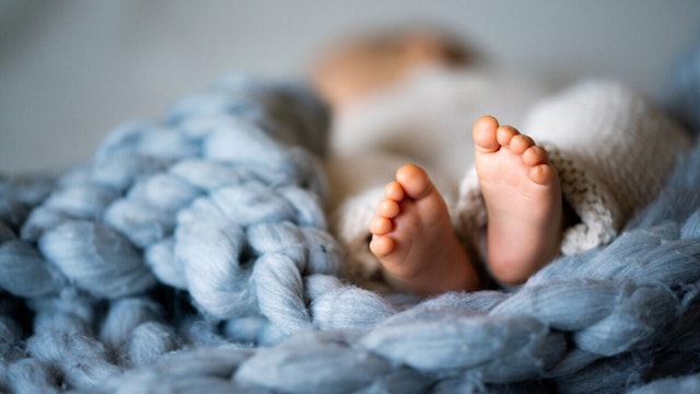Foot of newborn baby on warm blanket