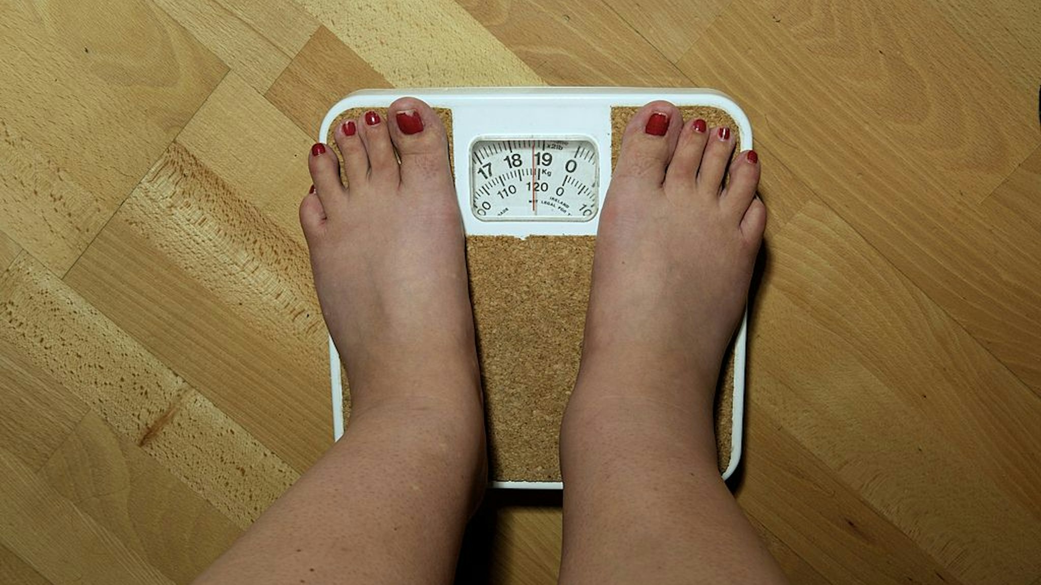LONDON, ENGLAND - SEPTEMBER 2006: An anonymous woman, 42, on the scales before her weight loss surgery. The scales stop at 19 stone, but she weighs nearly 20 stone (126kg) and is severely obese. She hopes to lose around a third of her weight by having a gastric band fitted. (Photo by Tina Stallard/Getty Images)