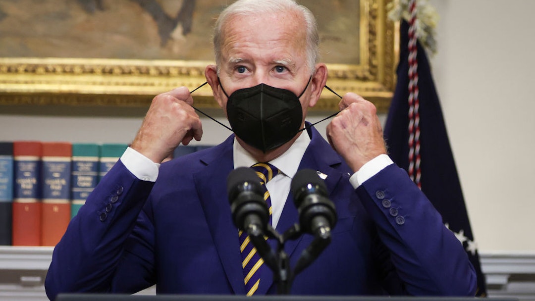 WASHINGTON, DC - AUGUST 24: U.S. President Joe Biden removes his mask before speaking on student loan debt in the Roosevelt Room of the White House August 24, 2022 in Washington, DC. President Biden announced steps to forgive $10,000 in student loan debt for borrowers who make less than $125,000 per year and cap payments at 5 percent of monthly income.