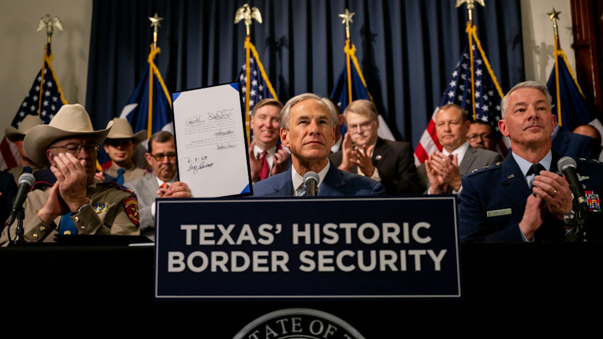 AUSTIN, TEXAS - JUNE 08: Texas Gov. Greg Abbott displays a signed bill during a news conference at the Texas State Capitol on June 08, 2023 in Austin, Texas. Gov. Abbott and Texas Department of Public Safety Director Steve McCraw joined bill authors, sponsors, legislators and law enforcement members in the signing of bills designated towards enhancing border security along the southern border.