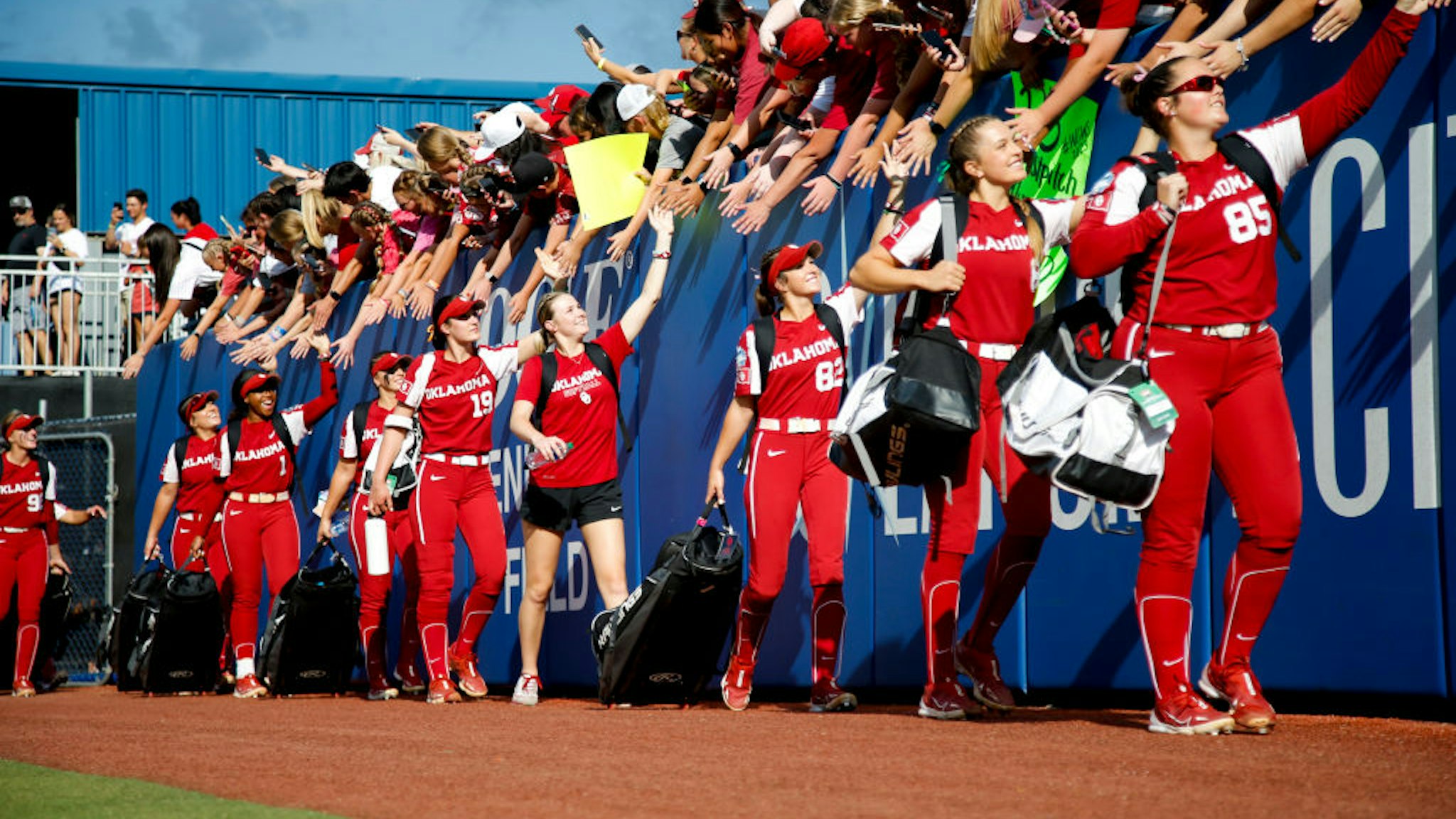 OKLAHOMA CITY, OKLAHOMA - JUNE 08: The Oklahoma Sooners high five fans before Game Two of the NCAA Division 1 Softball Championship against the Florida State Seminoles at USA Softball Hall of Fame Stadium on June 08, 2023 in Oklahoma City, Oklahoma. (Photo by Ian Maule/Getty Images)