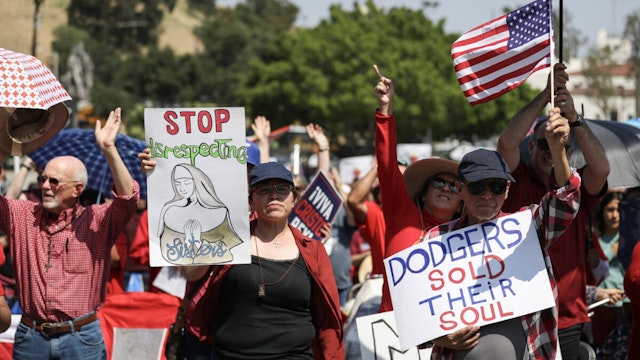 Protesters hold signs at a Catholics for Catholics event in response to the Dodgers' Pride Night event including the Sisters of Perpetual Indulgence, before the game between the Los Angeles Dodgers and the San Francisco Giants at Dodger Stadium on June 16, 2023 in Los Angeles, California.
