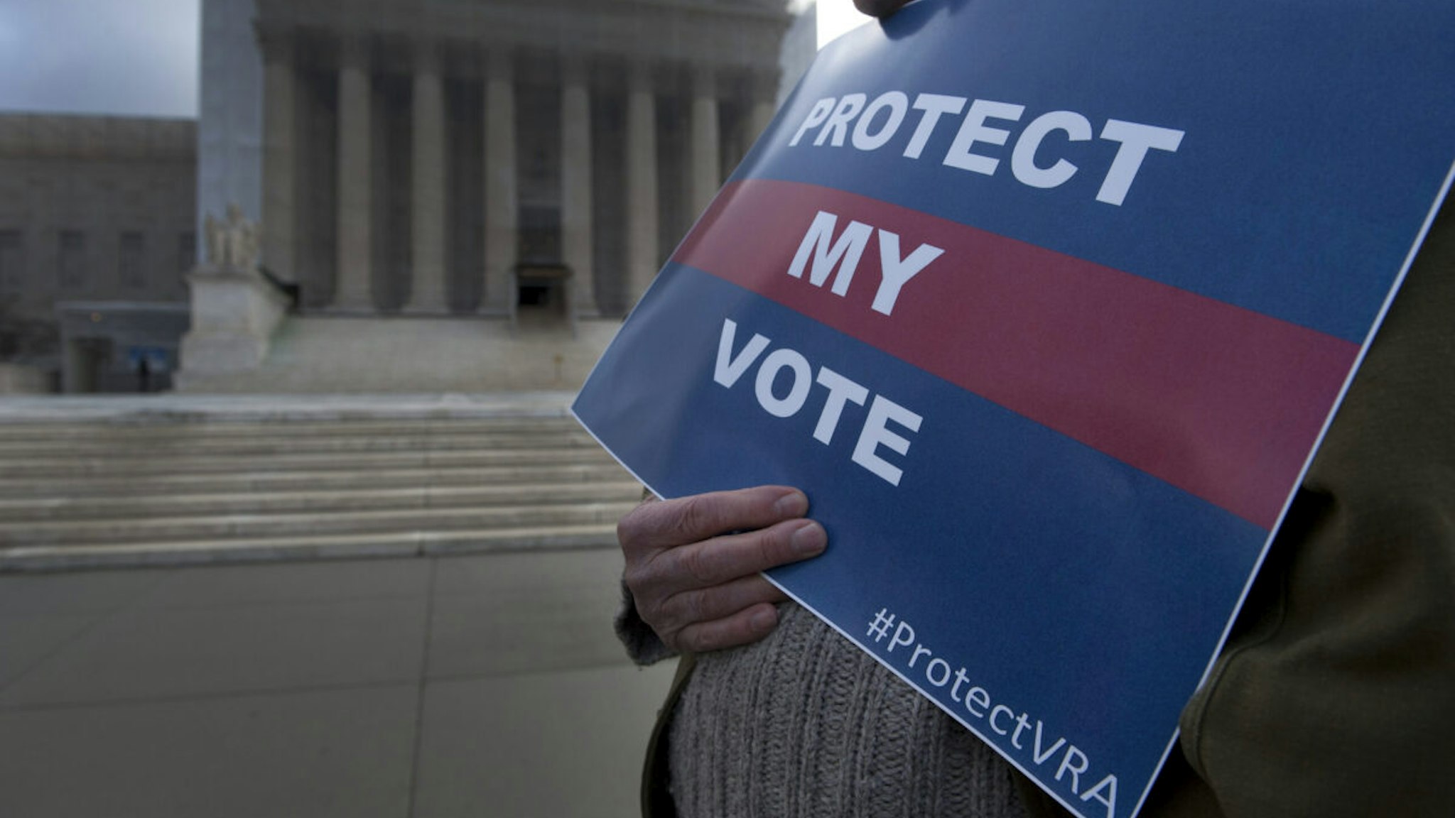 UNITED STATES - FEB 27 : Protesters hold signs outside the Supreme Court as the Shelby County, Alabama v. Holder oral arguments where set to begin at the Supreme Court on the importance of protecting the right to vote for all Americans on February 27, 2013.