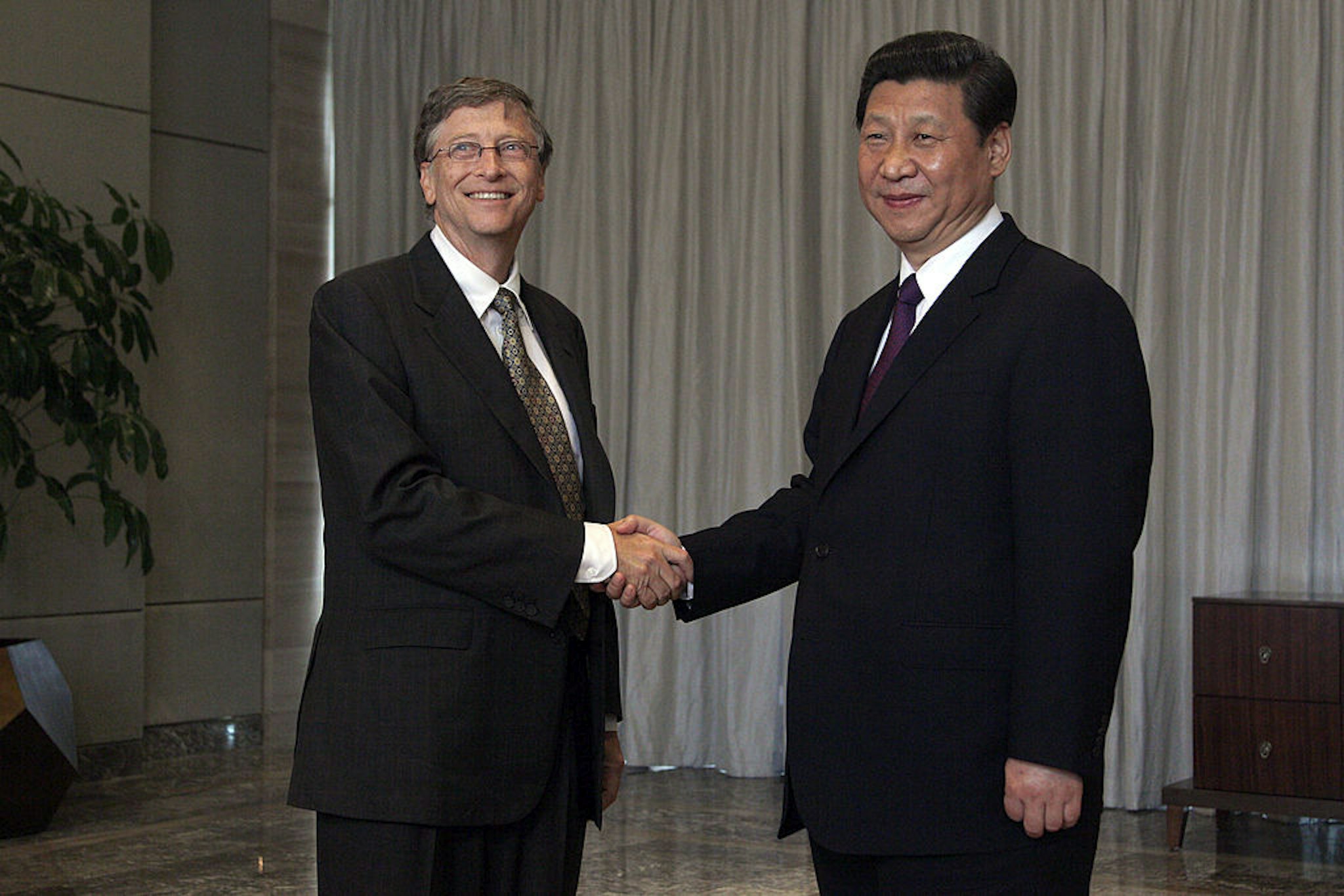 China's President Xi Jinping (R) shakes hands with Microsoft founder Bill Gates during the Boao Forum for Asia (BFA) annual conference in Boao on the southern Chinese resort island of Hainan on April 8, 2013. State and government leaders from Asia and other regions have been invited to attend three-days of economic meetings for the annual Boao Forum for Asia in Boao, a coastal town in south China's Hainan Province. AFP PHOTO / POOL /Tyrone Siu