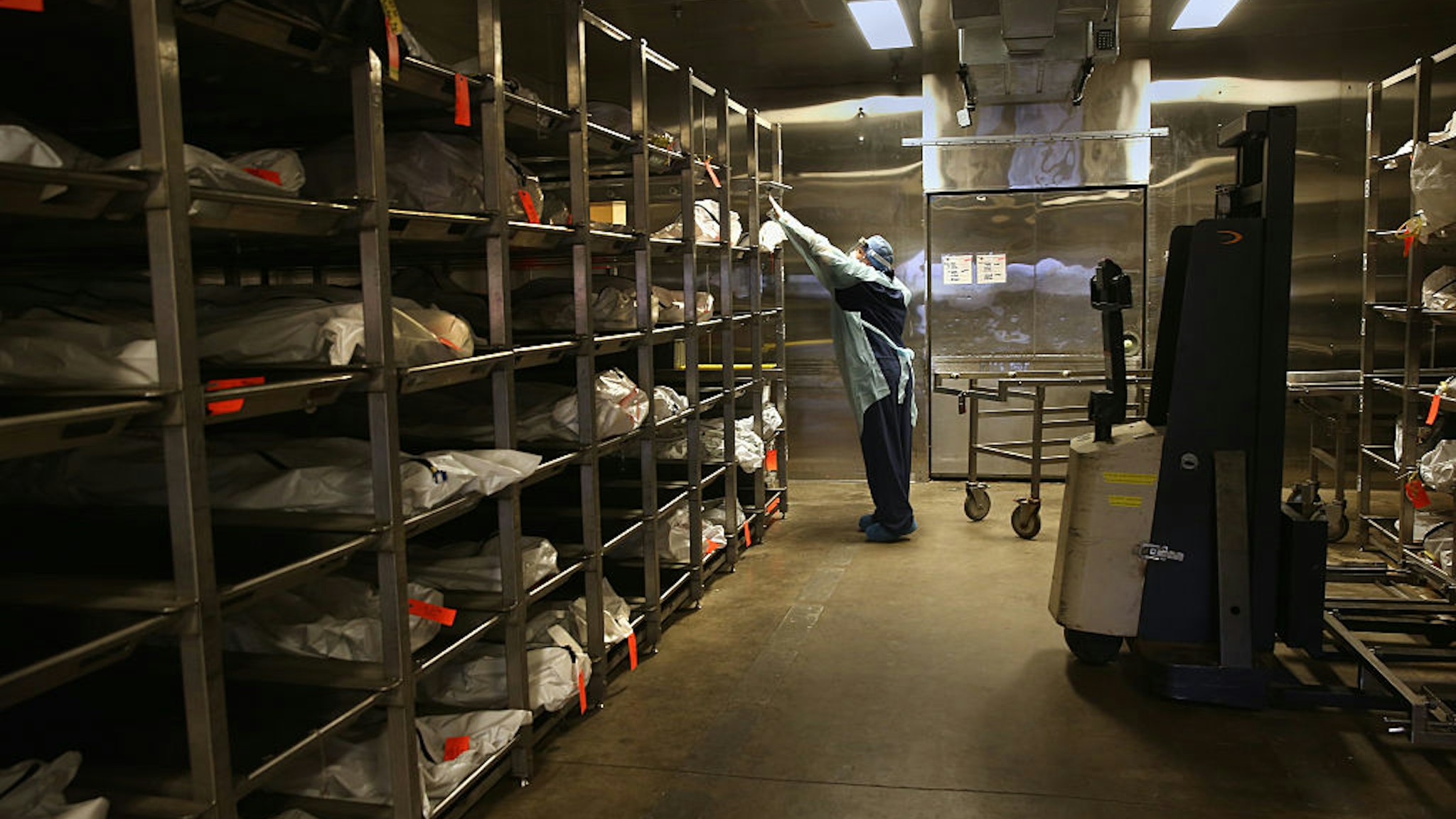 TUCSON, AZ - DECEMBER 09: Forensic technician Kristine Clor handles human remains in the refrigerated morgue of the Pima County Office of the Medical Examiner on December 9, 2014 in Tucson, Arizona. Forensic anthropologists attempt to identify the deceased by studying personal effects and bodily remains. Most are from undocumented immigrants, many of whom died of dehydration while crossing illegally into the U.S. from Mexico. The center currently has 90 bodies in the morgue and, on average, receives 176 per year, most found by ranchers and Border Patrol agents. Identified remains are repatriated, along with personal items, to their home countries, and the others will be cremated. (Photo by John Moore/Getty Images)