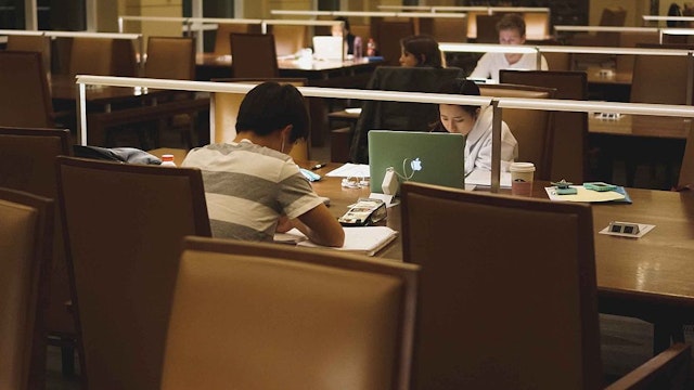 College students seated at study tables work from notebooks and laptops during the late hours of the night, the only light in the dim room coming from lamps on the tables, Albert Hutzler Reading Room, Brody Learning Commons, Johns Hopkins University, Baltimore, Maryland, March, 2014. Courtesy Eric Chen. (Photo by JHU Sheridan Libraries/Gado/Getty Images).