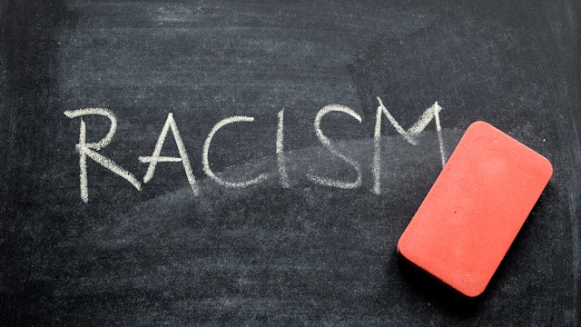 erasing racism, hand written word on blackboard being erased concept