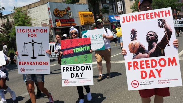 NEWARK, NEW JERSEY - JUNE 17: People march during a Juneteenth reparations rally on Broad Street on June 17, 2022 in Newark, New Jersey. The New Jersey Institute of Social Justice (NJISJ), elected officials, and activists marched and held a rally at City Hall celebrating the second year Juneteenth was recognized as a federal and state holiday in New Jersey. Legislation to make Juneteenth a federal holiday was introduced by Sen. Cory Booker (D-NJ) in 2020.