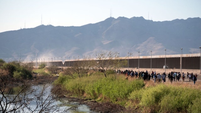 Migrants walk along the banks of the Rio Grande, on the border with the United States, in Ciudad Juarez, Chihuahua state, Mexico, on March 29, 2023