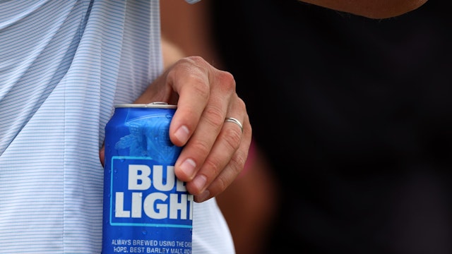 A fan holds a Bud Light beer during day three of the LIV Golf Invitational - DC at Trump National Golf Club on May 28, 2023 in Sterling, Virginia.