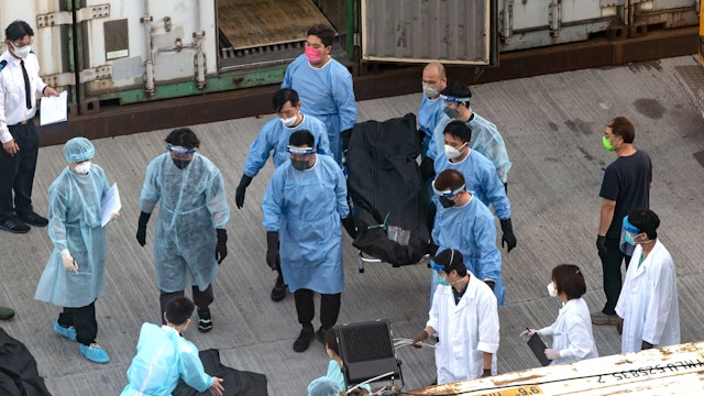 HONG KONG, CHINA - MARCH 11 : Workers transfer a body of a deceased person at a Mortuary on March 7, 2022 in Hong Kong, China. Hong Kong confirmed more than 29,000 new coronavirus infections with a records of 196 coronavirus-related fatalities in the past 24 hours, in addition to 98 deaths only reported on Friday. Poor vaccine coverage among elderly population results in city reporting the highest death rate in the world.