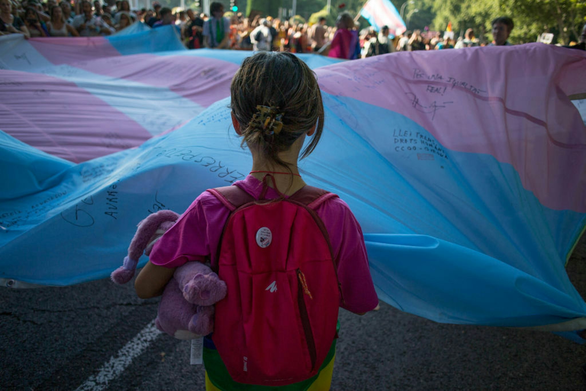 MADRID, SPAIN - 2022/07/09: A girl holds the Transgender Pride flag during the pride march held in one of the most important streets of Madrid. Thousands of people participated in the Madrid pride parade. After two years the march returned to normal with its floats that have characterised it years ago. (Photo by Luis Soto/SOPA Images/LightRocket via Getty Images)