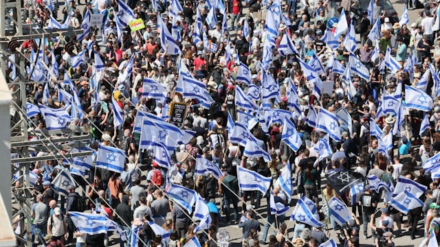 Israelis wave national flags as they protest against the government's controversial judicial reform bill in Tel Aviv on March 9, 2023. (Photo by JACK GUEZ / AFP)