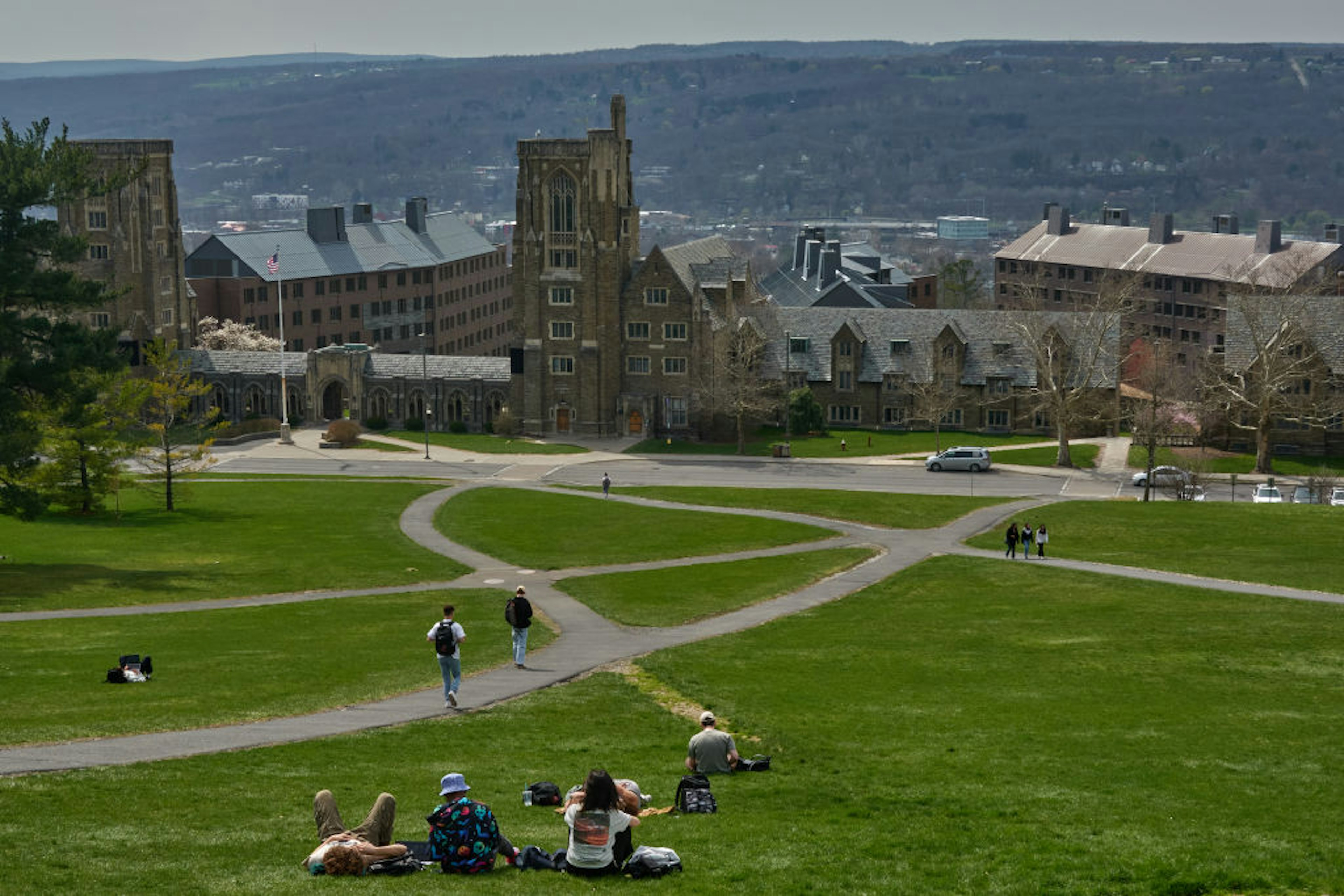 Students on Libe Slope at the Cornell University campus in Ithaca, US, on Tuesday, April 11, 2023. US college costs just keep climbing and the increase is pushing the annual price for the upcoming academic year at Ivy League schools toward yet another hold-on-to-your-mortarboard mark. Photographer: Bing Guan/Bloomberg via Getty Images