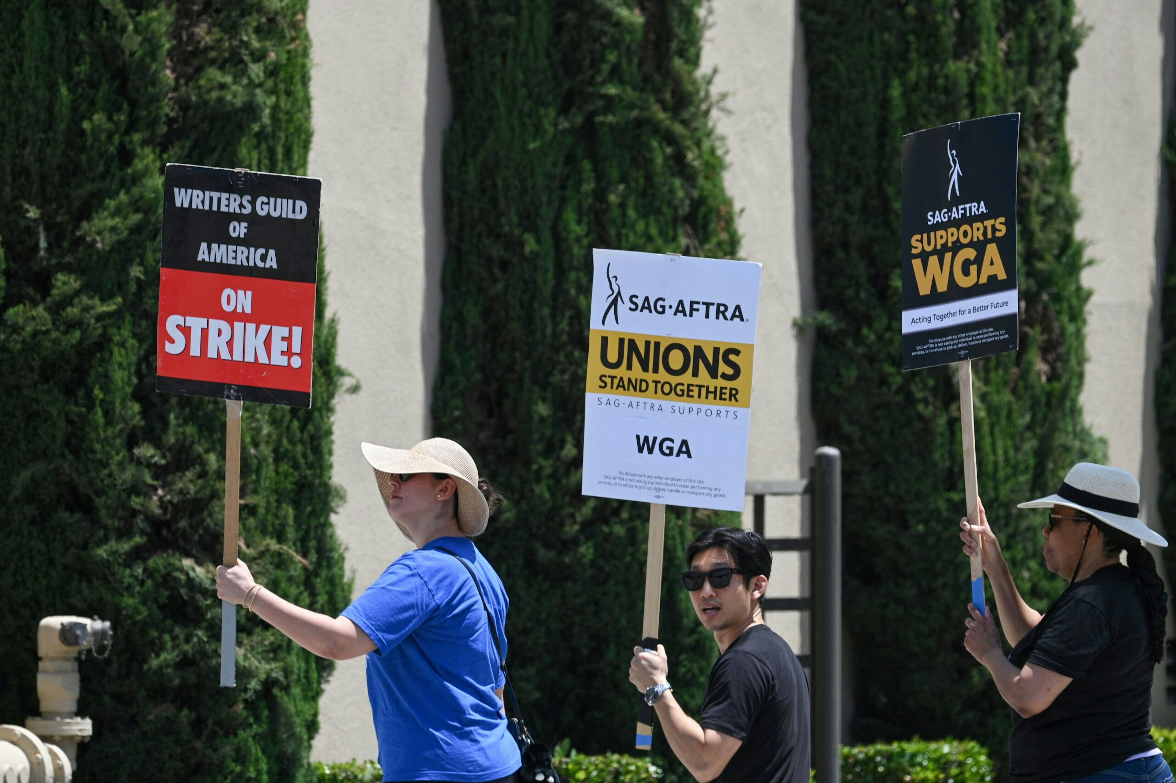 Hollywood writers and their supporters from the SAG AFTRA actors' union walk the picket line outside Warner Bros Studios in Burbank, California, June 30, 2023. Hollywood's summer of discontent could dramatically escalate this weekend, with actors ready to join writers in a massive "double strike" that would bring nearly all US film and television productions to a halt. The Screen Actors Guild (SAG-AFTRA) is locked in last-minute negotiations with the likes of Netflix and Disney, with the deadline fast approaching at midnight Friday (0700 GMT Saturday). (Photo by Robyn Beck / AFP) (Photo by ROBYN BECK/AFP via Getty Images)