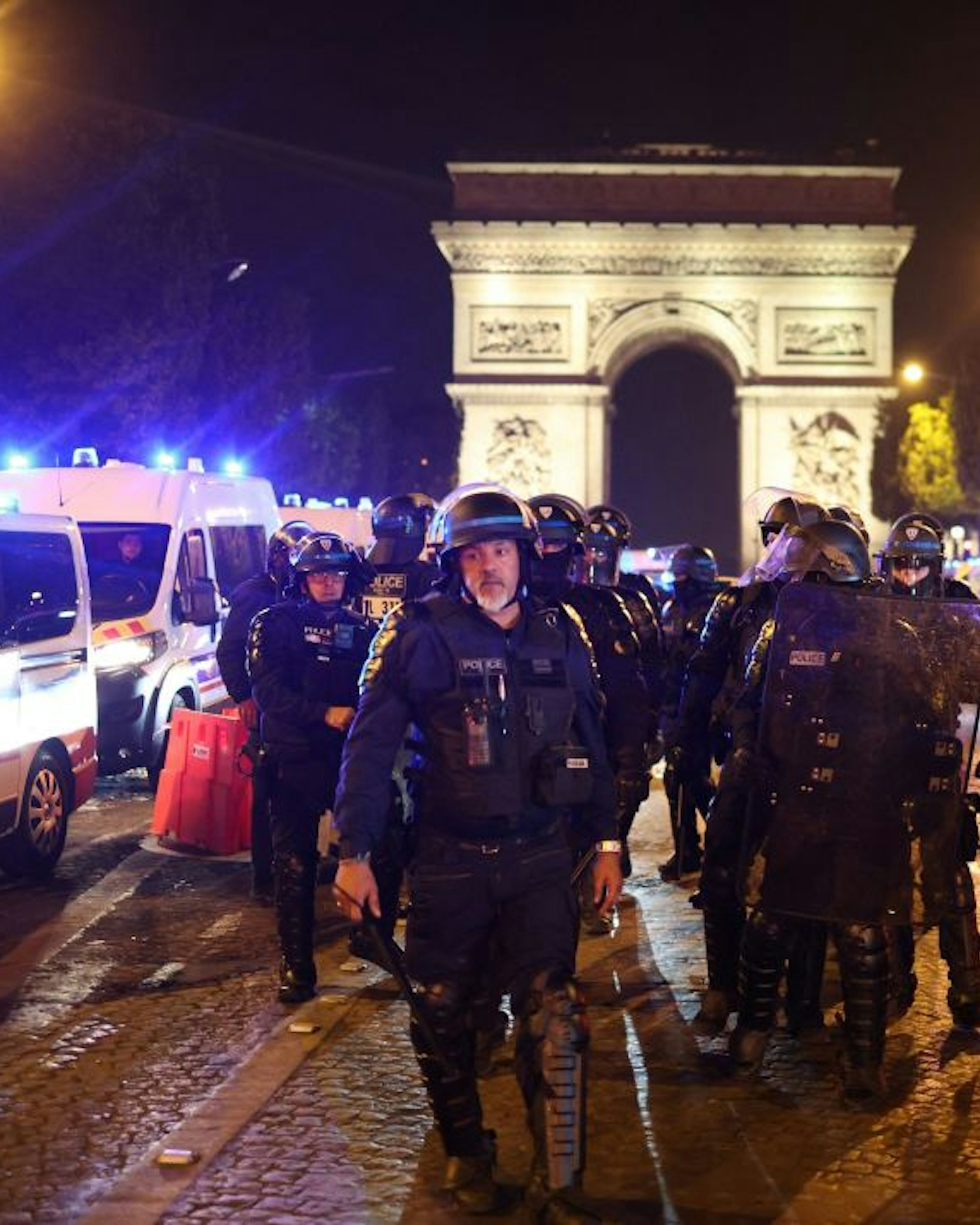 TOPSHOT - French police officers patrol in front of the Arc de Triomphe in the Champs Elysees area of Paris on July 1, 2023, five days after a 17-year-old man was killed by police in Nanterre, a western suburb of Paris. French police arrested 1311 people nationwide during a fourth consecutive night of rioting over the killing of a teenager by police, the interior ministry said on July 1, 2023. France had deployed 45,000 officers overnight backed by light armoured vehicles and crack police units to quell the violence over the death of 17-year-old Nahel, killed during a traffic stop in a Paris suburb on June 27, 2023. (Photo by CHARLY TRIBALLEAU / AFP) (Photo by CHARLY TRIBALLEAU/AFP via Getty Images)