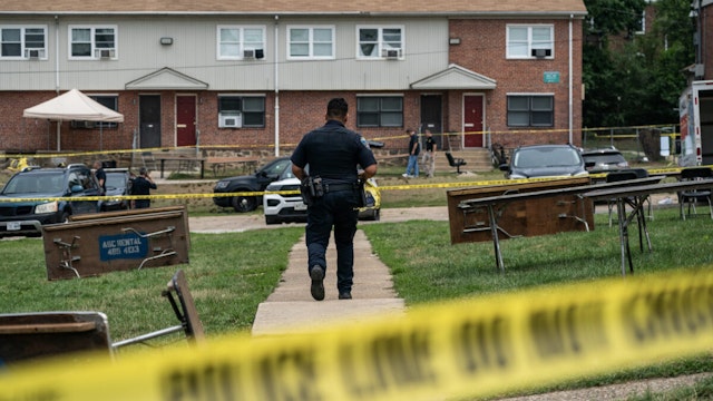 Baltimore Police investigate the site of a mass shooting in the Brooklyn Homes neighborhood on July 2, 2023 in Baltimore, Maryland. At least two people were killed and 28 others were wounded during the shooting at a block party on Saturday night.